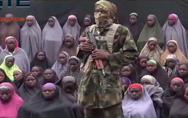 In this undated image taken from video distributed on August 14, 2016, an alleged Boko Haram member stands in front of a group of girls alleged to be some of the 276 abducted Chibok schoolgirls (Militant video/Site Institute via AP) In this undated image taken from video distributed on August 14, 2016, an alleged Boko Haram member stands in front of a group of girls alleged to be some of the 276 abducted Chibok schoolgirls (Militant video/Site Institute via AP)