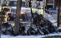 Firefighters use foam to extinguish the fire of a demolished aircraft after the plane crashed on Main Street in East Hartford, Connecticut, Tuesday, Oct. 11, 2016. (Jim Michaud/Journal Inquirer via AP)