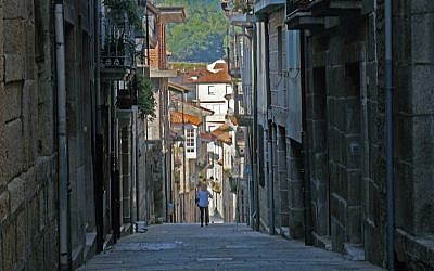 A tourist walking down the historic Jewish quarter of the town of Ribadavia in Spain, September 26, 2016. (Cnaan Liphshiz/JTA)