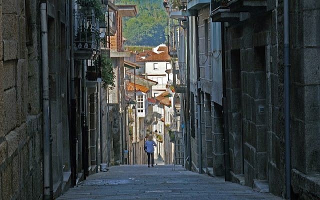 A tourist walking down the historic Jewish quarter of the town of Ribadavia in Spain, September 26, 2016. (Cnaan Liphshiz/JTA)