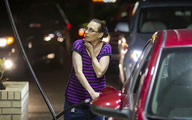 Beth Johnson fills up her car after waiting in line at a Sunoco gas station in advance of Hurricane Matthew in Mt. Pleasant, South Carolina, Tuesday, Oct. 4, 2016. (AP Photo/Mic Smith) Beth Johnson fills up her car after waiting in line at a Sunoco gas station in advance of Hurricane Matthew in Mt. Pleasant, South Carolina, Tuesday, Oct. 4, 2016. (AP Photo/Mic Smith)