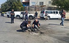 Police sappers dig out piece of a rocket launched from the Gaza Strip that struck a road in the southern city of Sderot on October 5, 2016. (Israel Police)