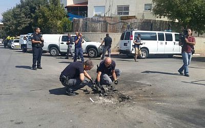 Police sappers dig out piece of a rocket launched from the Gaza Strip that struck a road in the southern city of Sderot on October 5, 2016. (Israel Police) Police sappers dig out piece of a rocket launched from the Gaza Strip that struck a road in the southern city of Sderot on October 5, 2016. (Israel Police)