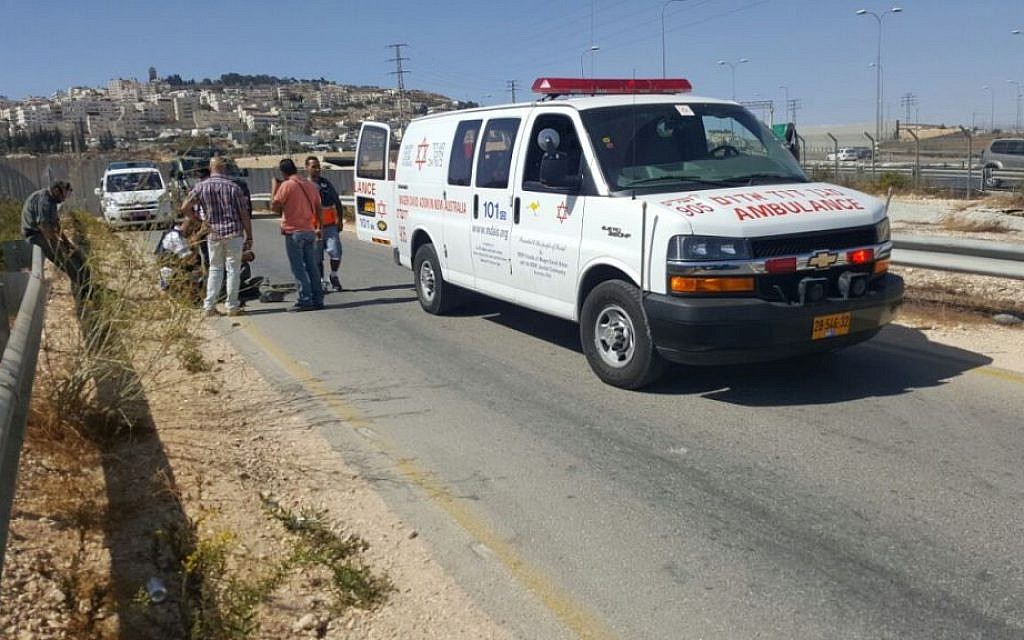 Illustrative: Medics from the Magen David Adom ambulance service treat an Israel Police officer and border guard that were injured when a car rammed through a checkpoint outside of Jerusalem on October 13, 2016. (Magen David Adom)