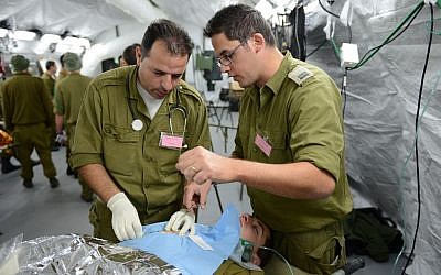 Two IDF doctors perform 'surgery' during a field hospital exercise in Beit Naballah, in central Israel, on December 9, 2013. (IDF Spokesperson's Unit) Two IDF doctors perform 'surgery' during a field hospital exercise in Beit Naballah, in central Israel, on December 9, 2013. (IDF Spokesperson's Unit)