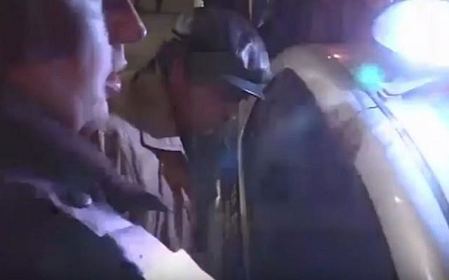 A man (right), possibly the suspected attacker, is restrained by a policeman at the scene of Saturday's attack on a Moscow synagogue that injured a security guard (YouTube screenshot)