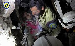 In this Wednesday, Sept. 28, 2016, photo provided by the Syrian Civil Defense group known as the White Helmets, shows a Civil Defense worker carrying a child out from under the rubble after airstrikes hit al-Shaar neighborhood in Aleppo. (Syrian Civil Defense White Helmets via AP)