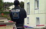 A German police officer stands outside the house where a neo-Nazi was arrested in a raid in Georgensmund, Bavaria, October 19, 2016. (Screenshot)