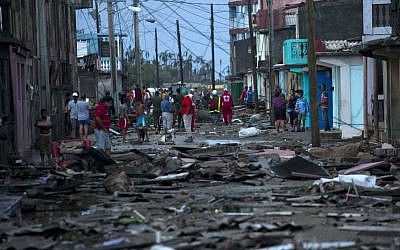 Red Cross workers and residents walk among the wreckage wrought by Hurricane Matthew in Baracoa, Cuba, Wednesday, October 5, 2016. (AP Photo/Ramon Espinosa)