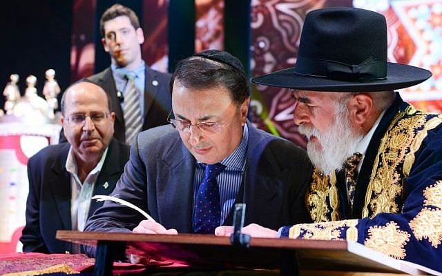 Lev Leviev, center, writing in a Torah scroll with Rabbi Eliyahu Yaakov, right, and Israel's then-defense minister Moshe Yaalon, in Jerusalem, March 23, 2014. (Israel Barddougo/World Congress of Bukhara Jews/JTA) Bukharian billionaire Lev Leviev, center, writing in a Torah scroll with Rabbi Eliyahu Yaakov, right, and Israel's then-defense minister Moshe Yaalon, in Jerusalem, March 23, 2014. (Israel Barddougo/World Congress of Bukhara Jews/JTA)