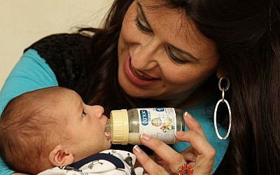 A mother feeds her baby Materna's milk substitute. February 28, 2011. (Nati Shohat/Flash90)