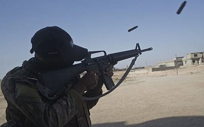 An Iraqi army soldier fires his rifle in the town of Shura, some 30 km south of Mosul, Iraq, October 29, 2016. (AP Photo/Marko Drobnjakovic)
