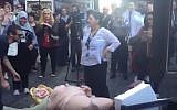A woman stands over a statue of depicting a naked Democrat presidential nominee Hillary Clinton in New York, October 18, 2016. (Lenny Brook/YouTube)