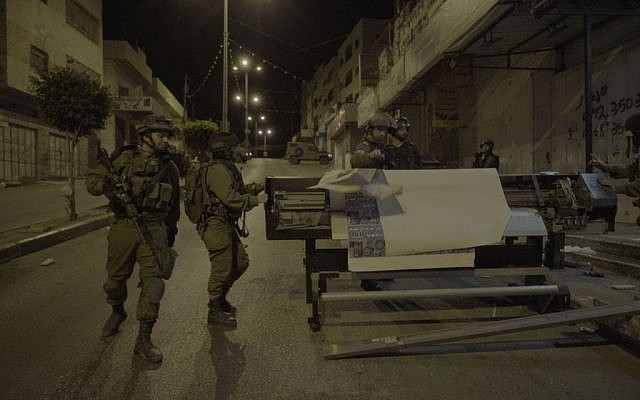 Soldiers removing equipment from a print shop which the IDF said produced posters and other material supporting terror attacks, in al-Ram in the West Bank, October 19, 2016. (IDF Spokesperson)