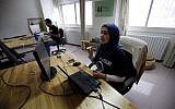 Palestinians work at the office of Red Crow, a startup that monitors security developments and sends real-time alerts and maps to clients, in Ramallah on August 17, 2016.  (AFP PHOTO / ABBAS MOMANI)