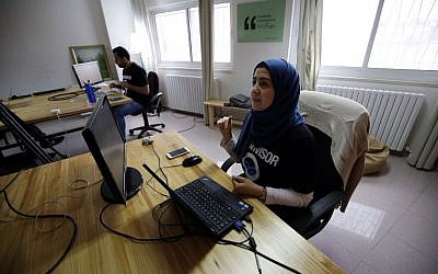Palestinians work at the office of Red Crow, a startup that monitors security developments and sends real-time alerts and maps to clients, in Ramallah on August 17, 2016.  (AFP PHOTO / ABBAS MOMANI)