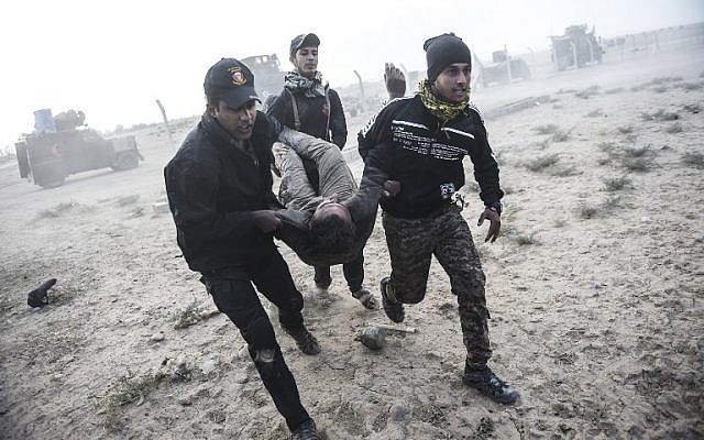 Iraqi Counter Terrorism Service members carry an injured comrade during clashes with Islamic State jihadists on the eastern edges of Mosul, on October 31, 2016. (AFP PHOTO / BULENT KILIC) Iraqi Counter Terrorism Service members carry an injured comrade during clashes with Islamic State jihadists on the eastern edges of Mosul, on October 31, 2016. (AFP PHOTO / BULENT KILIC)