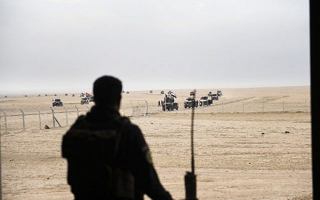 A member of the Iraqi Counter Terrorism Service (CTS) looks out at his comrades driving near the village of Bazwaya, on the eastern edges of Mosul, as they advance towards Iraq's last remaining Islamic State (IS) group stronghold on October 31, 2016. (AFP PHOTO / BULENT KILIC)
