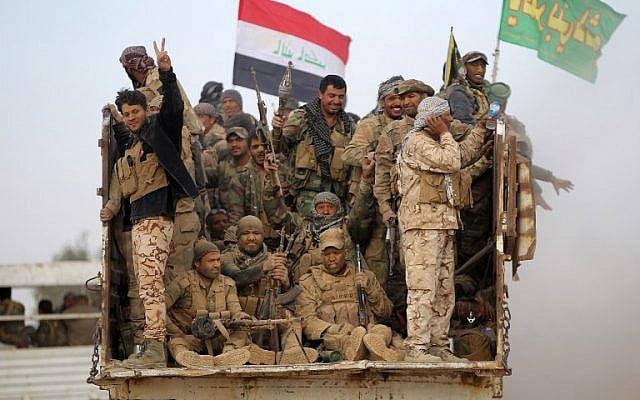 Shiite fighters from the Hashed al-Shaabi (Popular Mobilisation) flash the sign of victory from the back of a truck as they drive towards the village of Umm Sijan, south of Mosul, on October 31, 2016 during Iraqi forces' operation to recapture the main hub city from Islamic State (IS) group's jihadists. (AFP PHOTO / AHMAD AL-RUBAYE)