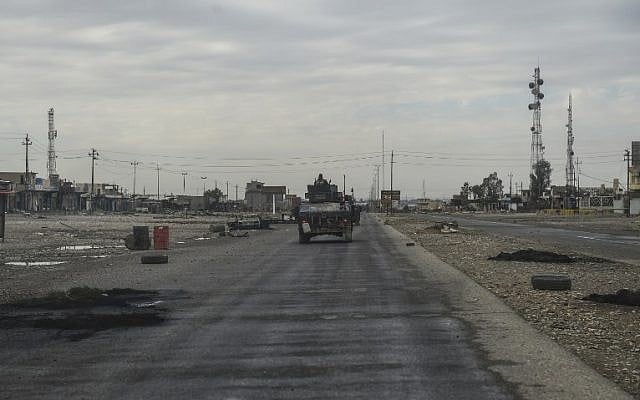 Iraqi army vehicles drive through the village of Gogjali, a few hundred metres of Mosul's eastern edge, on November 2, 2016, as they head towards the city during the ongoing operation to retake it from Islamic State group jihadists. (AFP PHOTO / BULENT KILIC)