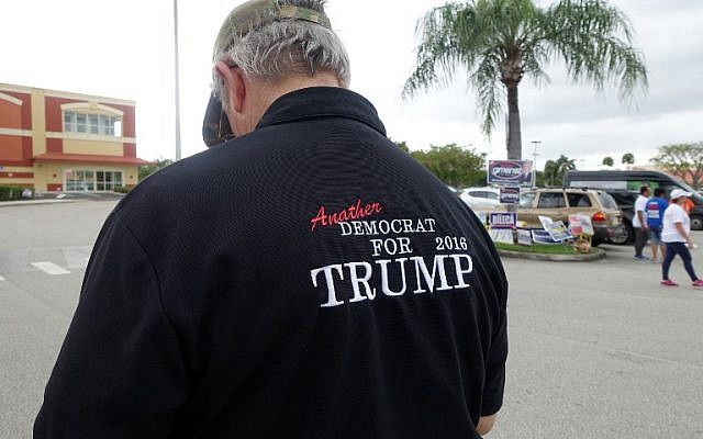 A man wearing a shirt that reads Another Democrat for Trump 2016 stands outside a Miami library polling place on November 1, 2016, and urges voters to pick Donald Trump for president. Early voting is under way in Miami, including at this library polling place where voters may cast ballots days ahead of the November 8 presidential election (AFP PHOTO / KERRY SHERIDAN)