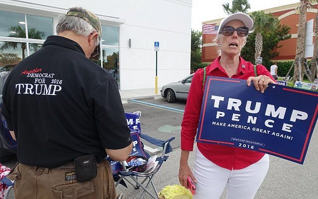 Volunteers Michael Calsetta and Katrina Vidal campaign for US Republican candidate Donald Trump outside a polling place in Miami, on November 1, 2016, in a last-ditch attempt to sway voters before they cast their early ballots in the crucial battleground state of Florida. (AFP PHOTO / KERRY SHERIDAN)