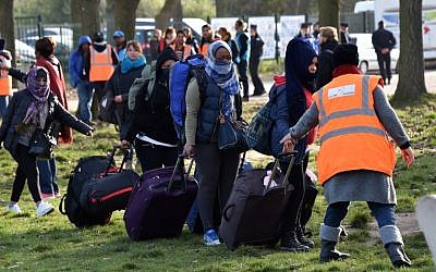Migrants carry their luggage as they walk to climb into a bus after leaving the "Jules Ferry" reception center, next to the recently demolished "Jungle" migrant camp after a massive operation to clear the settlement, on November 3, 2016, in Calais. (AFP PHOTO / PHILIPPE HUGUEN)