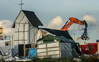 Members of the demolition crew tear down the Orthodox church inside the "Jungle" migrant camp in Calais, northern France, during a massive operation to clear the settlement, on November 3, 2016. (AFP PHOTO / PHILIPPE HUGUEN)