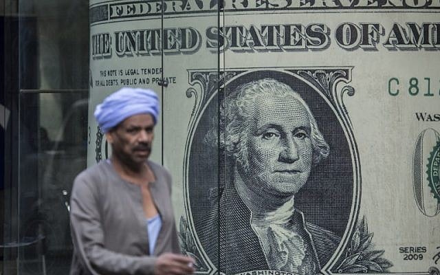 A man walks past a currency exchange shop displaying a giant US dollars banknote in downtown Cairo on November 3, 2016. (AFP PHOTO / KHALED DESOUKI) A man walks past a currency exchange shop displaying a giant US dollars banknote in downtown Cairo on November 3, 2016. (AFP PHOTO / KHALED DESOUKI)