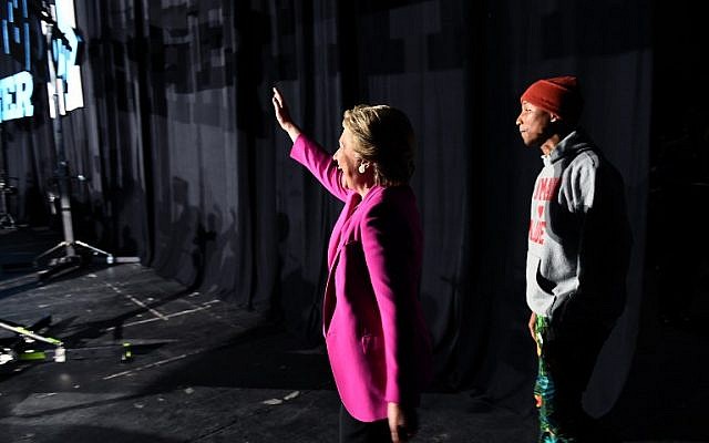 US Democratic presidential nominee Hillary Clinton waves as singer Pharrell Williams follows during a campaign rally in Raleigh, North Carolina, on November 3, 2016. ( AFP PHOTO / Jewel SAMAD)