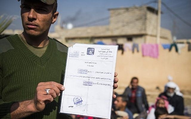 An Iraqi soldier from the Iraqi army 9th armored division holds a death certificate issued by the Islamic State group next to a base adjacent to the Al-Intissar neighborhood of Mosul, on November 7, 2016. (AFP/Odd ANDERSEN)