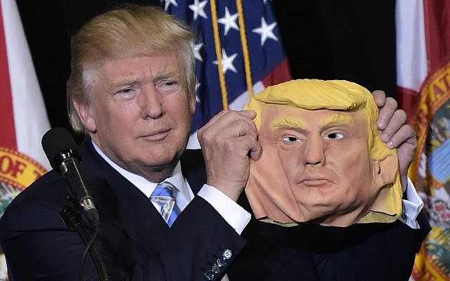 Republican presidential nominee Donald Trump holds a mask of himself which he picked up from supporter during a rally in the Robarts Arena of the Sarasota Fairgrounds in Florida on November 7, 2016.(AFP PHOTO/MANDEL NGAN) Republican presidential nominee Donald Trump holds a mask of himself which he picked up from supporter during a rally in the Robarts Arena of the Sarasota Fairgrounds in Florida on November 7, 2016.(AFP PHOTO/MANDEL NGAN)