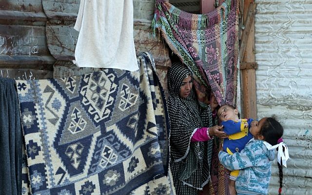 A Palestinian woman and her children stand by their home in Beit Hanun, near the Erez border crossing with Israel, in the northern Gaza Strip on November 8, 2016. (AFP PHOTO / MOHAMMED ABED) A Palestinian woman and her children stand by their home in Beit Hanun, near the Erez border crossing with Israel, in the northern Gaza Strip on November 8, 2016. (AFP PHOTO / MOHAMMED ABED)