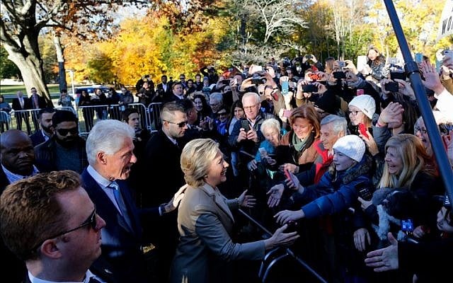 Democratic presidential nominee Hillary Clinton (C) and her husband Bill greet supporters after casting her vote in Chappaqua, New York on November 8, 2016. After an exhausting, wild, bitter, and sometimes sordid campaign, Americans finally began voting Tuesday for a new president: either the billionaire populist Donald Trump or Hillary Clinton, seeking to become the first woman to win the White House. (EDUARDO MUNOZ ALVAREZ/AFP)