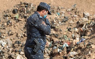 A member of the Iraqi forces checks a mass grave they discovered in the Hamam al-Alil area on November 7, 2016 after they recaptured the area from Islamic State (IS) group jihadists during the ongoing operation to retake Mosul, the last IS-held Iraqi city. (AHMAD AL-RUBAYE / AFP)
