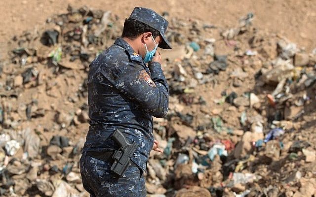A member of the Iraqi forces checks a mass grave they discovered in the Hamam al-Alil area on November 7, 2016 after they recaptured the area from Islamic State (IS) group jihadists during the ongoing operation to retake Mosul, the last IS-held Iraqi city. (AHMAD AL-RUBAYE / AFP) A member of the Iraqi forces checks a mass grave they discovered in the Hamam al-Alil area on November 7, 2016 after they recaptured the area from Islamic State (IS) group jihadists during the ongoing operation to retake Mosul, the last IS-held Iraqi city. (AHMAD AL-RUBAYE / AFP)