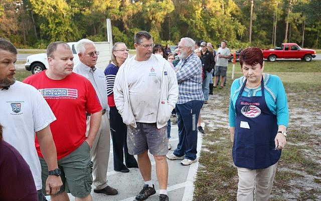 A precinct clerk walks past voters waiting to cast their ballots in the presidential election at a polling station in Christmas, Florida on November 8, 2016. (AFP PHOTO / Gregg Newton)
