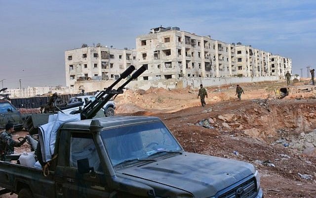 Syrian pro-government forces walk past a pick-up truck mounted with an anti-aircraft machine gun as they hold a position in Aleppo's 1070 district on November 8, 2016, after seizing it from rebel fighters. (AFP PHOTO / GEORGES OURFALIAN)