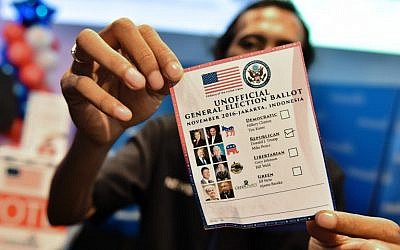 An Indonesian man holds up an unofficial ballot for a fun-vote for the US presidential election during an event organised by the US Embassy, at a mall in Jakarta on November 9, 2016. (AFP PHOTO / BAY ISMOYO)