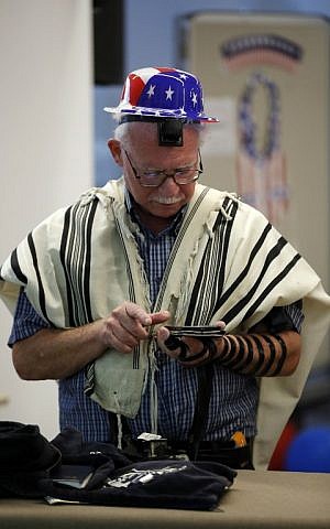 A man prays as he checks for the results of the US presidential elections on a device, at the American Center in Jerusalem, on November 9, 2016. (AFP PHOTO / THOMAS COEX)