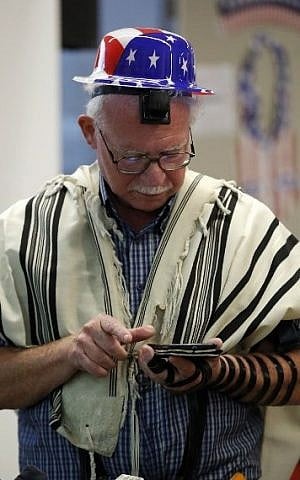 An Israeli Jew prays as he checks for the results of the US presidential elections on a device, at the American Center in Jerusalem, on November 9, 2016. (AFP PHOTO / THOMAS COEX)