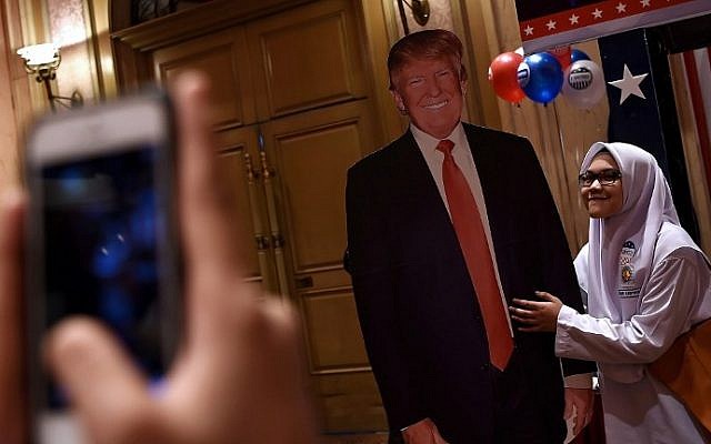 A Malaysian Muslim schoolgirl poses for a photograph with a cut-out of President-elect Donald Trump during an event organized to follow the election results in Kuala Lumpur on November 9, 2016. (AFP/Manan Vatsyayana) A Malaysian Muslim schoolgirl poses for a photograph with a cut-out of President-elect Donald Trump during an event organized to follow the election results in Kuala Lumpur on November 9, 2016. (AFP/Manan Vatsyayana)