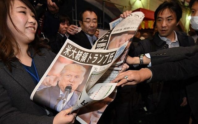 A woman gives out extra editions of a newpaper reporting the victory of Donald Trump in the US presidential election in Tokyo on November 9, 2016. (AFP PHOTO / TORU YAMANAKA) A woman gives out extra editions of a newpaper reporting the victory of Donald Trump in the US presidential election in Tokyo on November 9, 2016. (AFP PHOTO / TORU YAMANAKA)