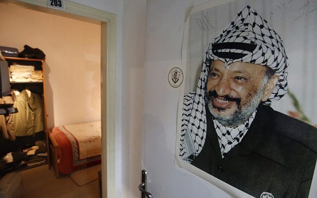 A picture taken on November 9, 2016 shows a large printed photograph of late Palestinian leader Yasser Arafat hanging outside a door leading to a recreation of the small bedroom where he spent his final years at the new Arafat Museum in the West Bank city of Ramallah. (AFP/Abbas Momani) A picture taken on November 9, 2016 shows a large printed photograph of late Palestinian leader Yasser Arafat hanging outside a door leading to a recreation of the small bedroom where he spent his final years at the new Arafat Museum in the West Bank city of Ramallah. (AFP/Abbas Momani)