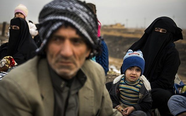 Newly arrived displaced Iraqis await transport in the Iraqi Kurdish checkpoint village of Shaqouli, about 35 kilometres east of Mosul, on November 10, 2016, after they fled their homes in Mosul. .(AFP PHOTO / Odd ANDERSEN)
