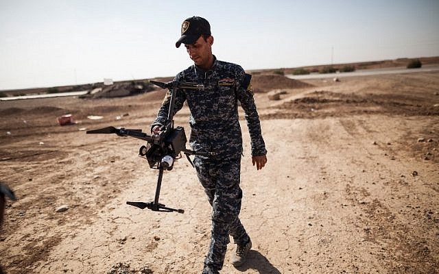 An Iraqi Policeman carries a drone near the village of Arbid, on the southern Mosul front, during the military operation to retake Mosul from the Islamic State (IS) group, November 12, 2016. (AFP/Achilleas ZAVALLIS)