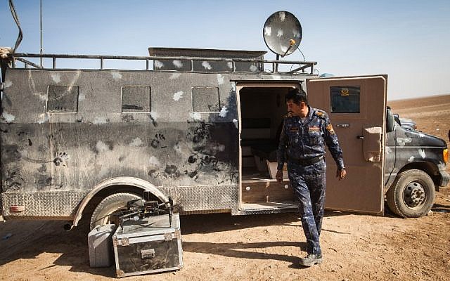 Lieutenant Colonel Hussein Hussein of the Iraqi police, steps outside an armoured vehicle turned into a drone control center, near the village of Arbid, on the southern Mosul front, November 12, 2016. (AFP/Achilleas ZAVALLIS)