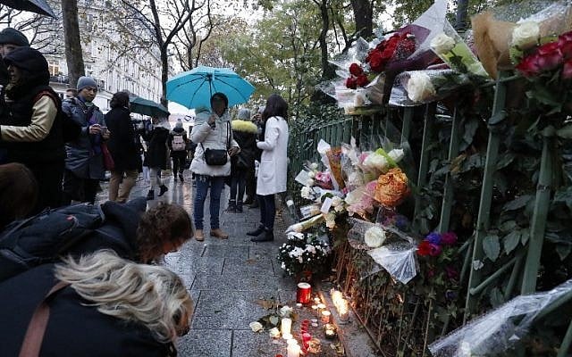 People gather around flowers and candles laid next to the Bataclan concert hall in Paris on November 12, 2016, a few hours before the reopening concert by British musician Sting to mark the first anniversary of the November 13 Paris attacks.(AFP PHOTO / FRANCOIS GUILLOT) People gather around flowers and candles laid next to the Bataclan concert hall in Paris on November 12, 2016, a few hours before the reopening concert by British musician Sting to mark the first anniversary of the November 13 Paris attacks.(AFP PHOTO / FRANCOIS GUILLOT)