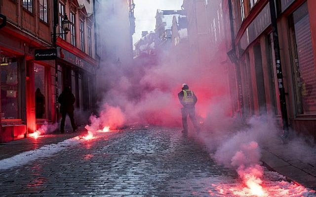 Counter-protesters throw flairs toward police officers as they demonstrate against the neo-nazi Nordic Resistance Movement (Nordiska motstandsrorelsens) rally, in central Stockholm on November 12, 2016. (AFP PHOTO / JONATHAN NACKSTRAND)