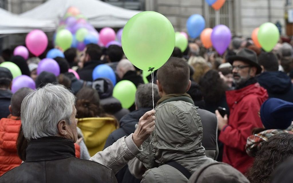 Parisians  about to release balloons in front of the city hall of the 11th arrondissement of Paris, on November 13, 2016, to mark the first anniversary of the Paris terror attacks. (AFP PHOTO / ALAIN JOCARD)